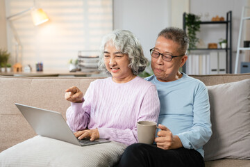 Retired Couple  Having Morning Coffee Together. surfing internet while resting in livingroom.