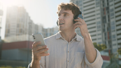 Happy Caucasian man smiling enjoyment listening music headphones earphones electronic gadget device...
