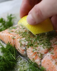 Person is cutting a lemon and placing it on top of a piece of salmon