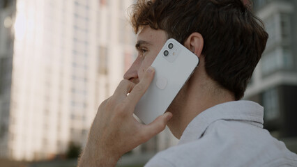 Back view close up head unrecognizable unknown man talking mobile phone cellphone answering call...