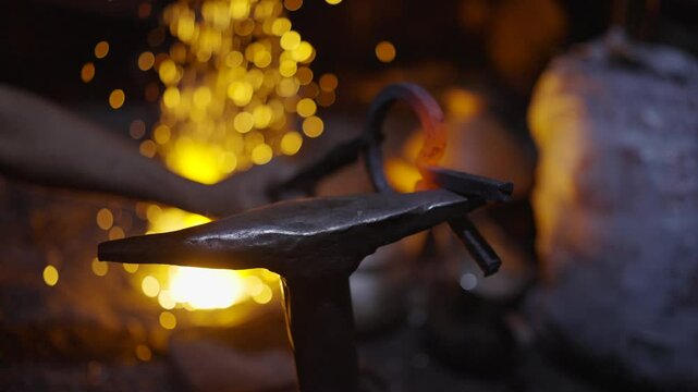 Super slow motion close up shot of a traditional Moroccan blacksmith forging a glowing metal tool with fire and sparks at a night market in Marrakech