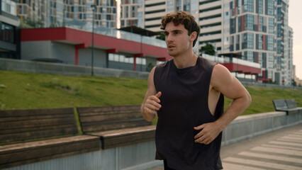 Caucasian European young man running runner male guy athlete sport city motivated jog outdoors...