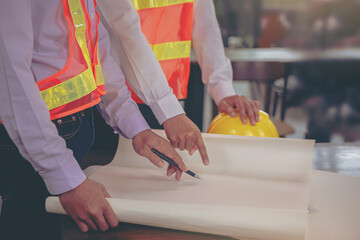 Structural engineer and architect and foreman worker with blueprints discuss, plan working for the building construction site office. Construction collaboration concept