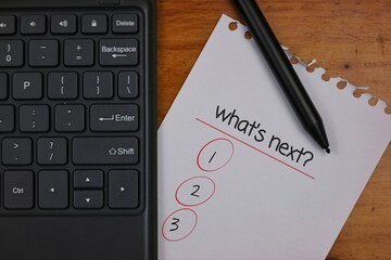 Keyboard and Paper Checklist with Pen Indicating Planning or Task Prioritization