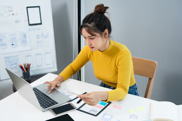 UI and UX designs for mobile app on laptop computer screen. User interface development planning for...