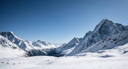 Majestic snow-covered mountains reach towards a clear blue sky, creating a stunning winter landscape perfect for travel, adventure, and scenic views in the alpine region.
