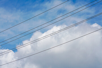 clouds over blue sky and electric lines 