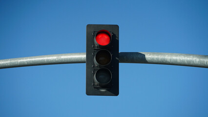 red traffic light on blue sky