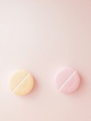 Obraz premium Two simple pills, one pastel yellow and one pastel pink, arranged side by side on a pale pink backdrop