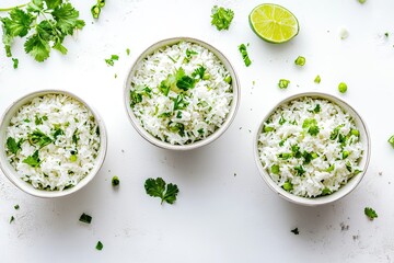 Three small white bowls of rice topped with fresh herbs and a lime