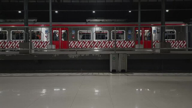 Commuter line (KRL) trains start departing from the station platform at night to the next station stop.