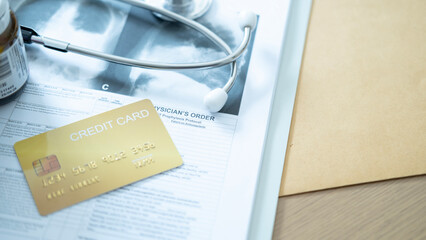 Golden credit card on medical order sheet beside medicines and stethoscope, highlighting healthcare charges.