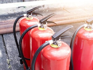 Red fire extinguisher with outdoor background for the concept of controlling small fires.
