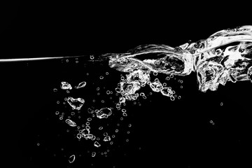 黒の背景に水面に浮上する気泡.