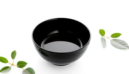 Black ceramic bowl with green leaves on a white background minimalist style