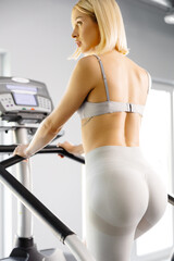 Young woman in sportswear working out at the gym. She is working out on stairway simulator