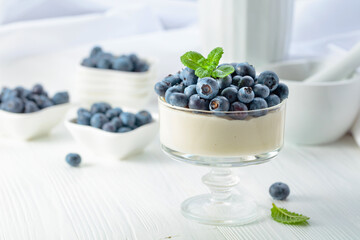 Mascarpone cream with fresh blueberries in a clear bowl.