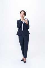 携帯を持ち考えるスーツを着た女性