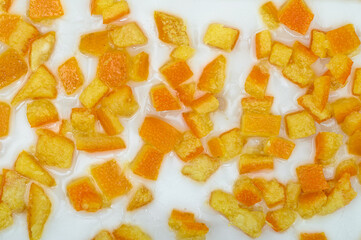 Close-up texture of a cake topped with sugar icing and candied orange peel