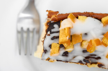 Close-up of a piece of homemade cake beautifully decorated with icing and candied orange peel,...