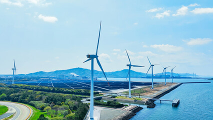 Aerial view of a hybrid power plant with wind turbines and solar panels