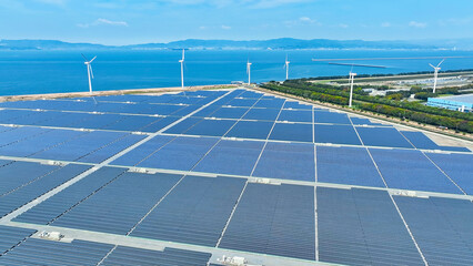 Aerial view of a hybrid power plant with wind turbines and solar panels