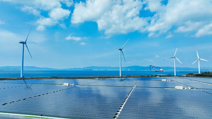 Aerial view of a hybrid power plant with wind turbines and solar panels
