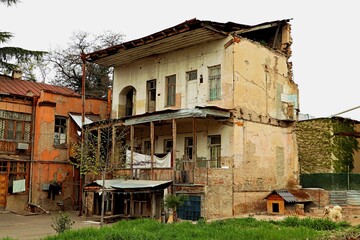 An old residential building with a lawn is falling into disrepair due to lack of proper maintenance...