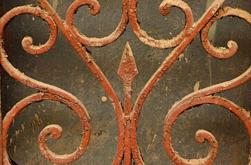 the shaped element of the lattice on the window, covered with a thick layer of brown paint, cracked with time.