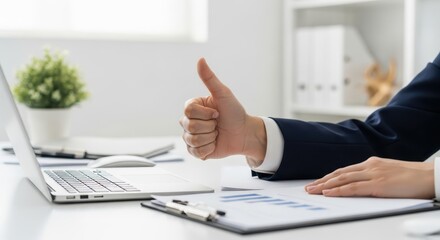 A thumbs up gesture shows business success at the office
