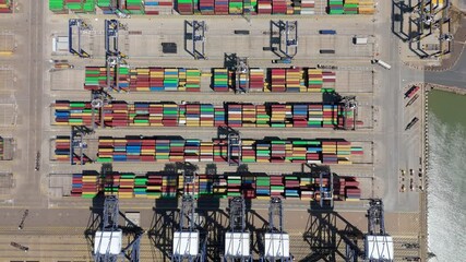 Aerial drone shot Felixstowe busy port cargo ships, shipping containers, huge cranes, loading and unloading heavy goods vehicles summer maritime business England UK - Powered by Adobe