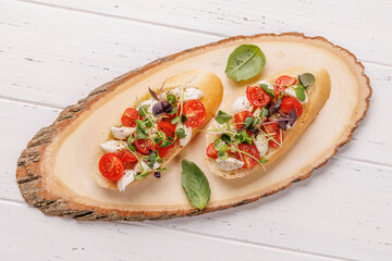 Tasty antipasto toasts featuring classic caprese with mozzarella and tomatoes, and savory prosciutto with herbs