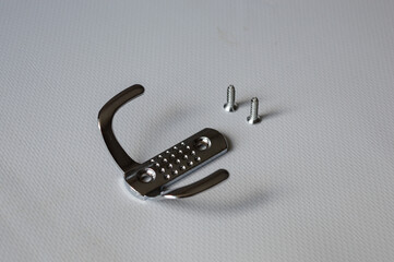 metal wall hook with screws on white background, useful for concepts like home organization, DIY...