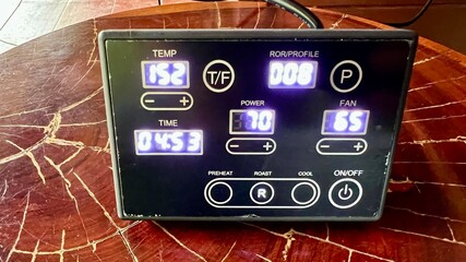 A closeup shot of a digital coffee roasting machine scale on a wooden surface