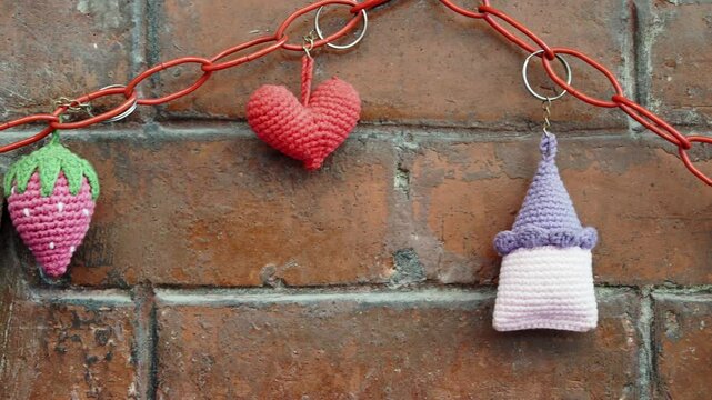 Handmade crochet keychains displayed on a brick wall