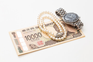 一万円札と腕時計と真珠のネックレス