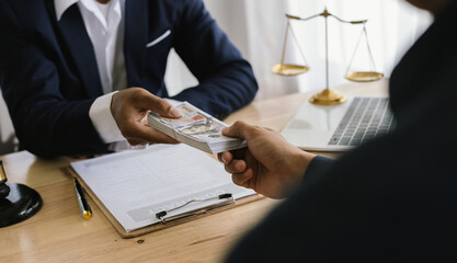 Lawyer giving advice and handing over cash during a legal meeting, symbolizing financial...