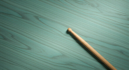 Single drumstick on teal wood background perfect for music related projects