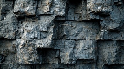 Fototapeta premium Rough, layered dark-gray stacked stone wall with crevices