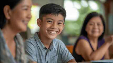 Boy smiles while engaged in a joyful learning activity with attentive female participants in a bright, casual setting