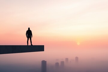 Fototapeta premium Engineer construction site concept. A silhouette stands on a ledge, overlooking a foggy cityscape at sunset.