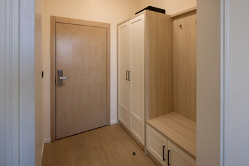 Entrance hallway of a hotel room with a brown wooden decorative wall