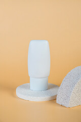 Plastic white tube for cream or lotion. Skin care or sunscreen cosmetic with stylish props on cream background.