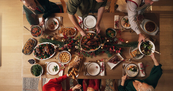 Festive, meal and people in home, dinner and celebration of Christmas with food at night or reunion. Above, group and family with feast for thanksgiving, evening and together on holiday in house