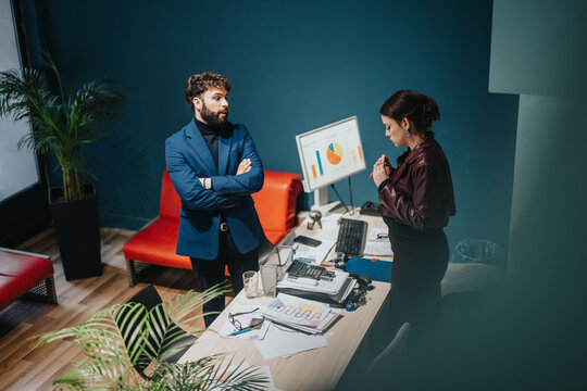 Business professionals collaborating on a project while reviewing data reports in an office workspace.