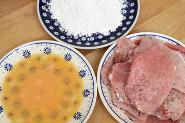 Making dinner, ingredients for pork chops, egg, flour, meat slices