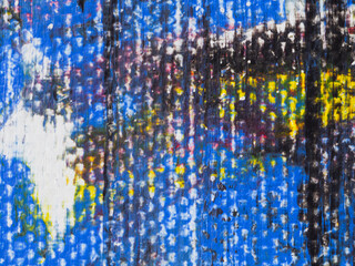 Colorful abstract artwork displayed on a textured surface in an artistic studio during daylight