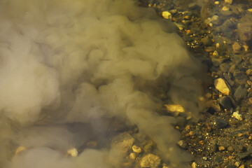 Muddy Water Mixing with River Rocks Underwater Close-up