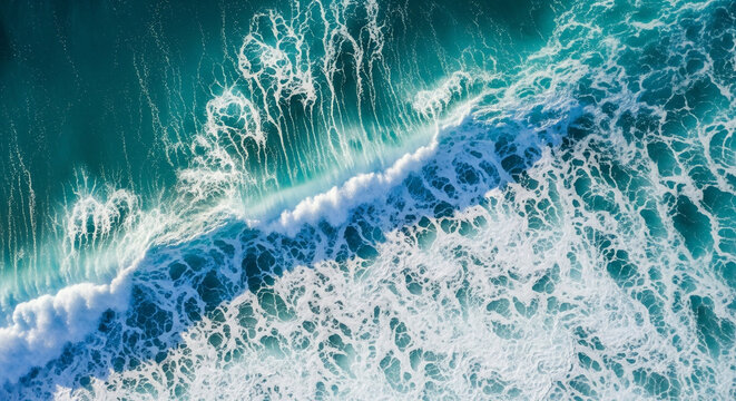 Aerial view of powerful ocean waves crashing on the surface, creating white foam and turquoise water patterns. - Powered by Adobe