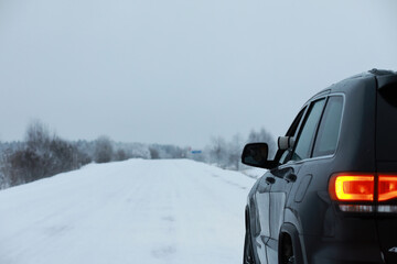 Car in the winter forest. Traveling through a snowy park by car during the Christmas holidays.